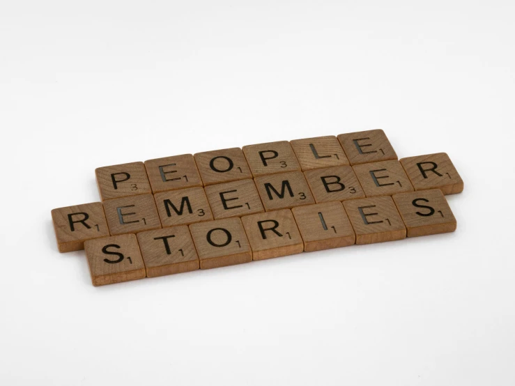 scrabbles spelling people remember stories on a white background, by Ruth Simpson, pexels contest winner, tan, remembrance, official product photo, etched inscriptions