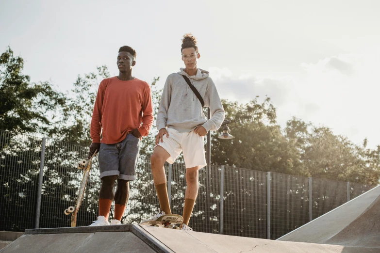 a couple of young men standing on top of a skateboard ramp, trending on unsplash, white shorts and hiking boots, diverse outfits, 15081959 21121991 01012000 4k, prosthetic limbs