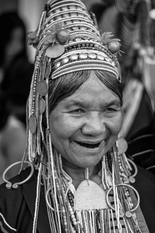 a black and white photo of a woman smiling, a black and white photo, pexels contest winner, sumatraism, wholesome techno - shaman lady, thailand, head piece, vibrant colour