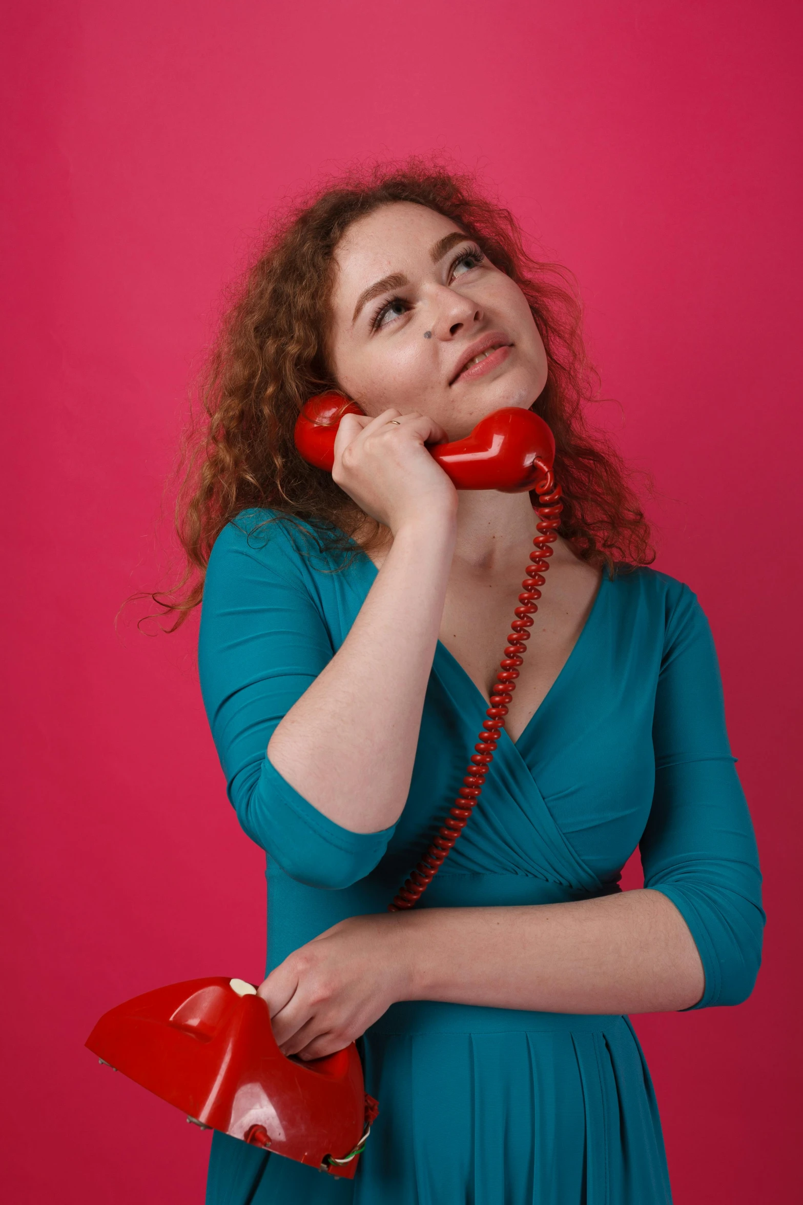 a woman in a blue dress talking on a red phone, promo photo, curly haired, pink and red color scheme, taken in 2 0 2 0