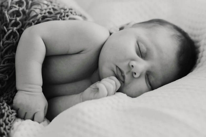 a black and white photo of a baby sleeping, by Ruth Simpson, pexels, instagram post, fertility, handsome girl, carefully crafted