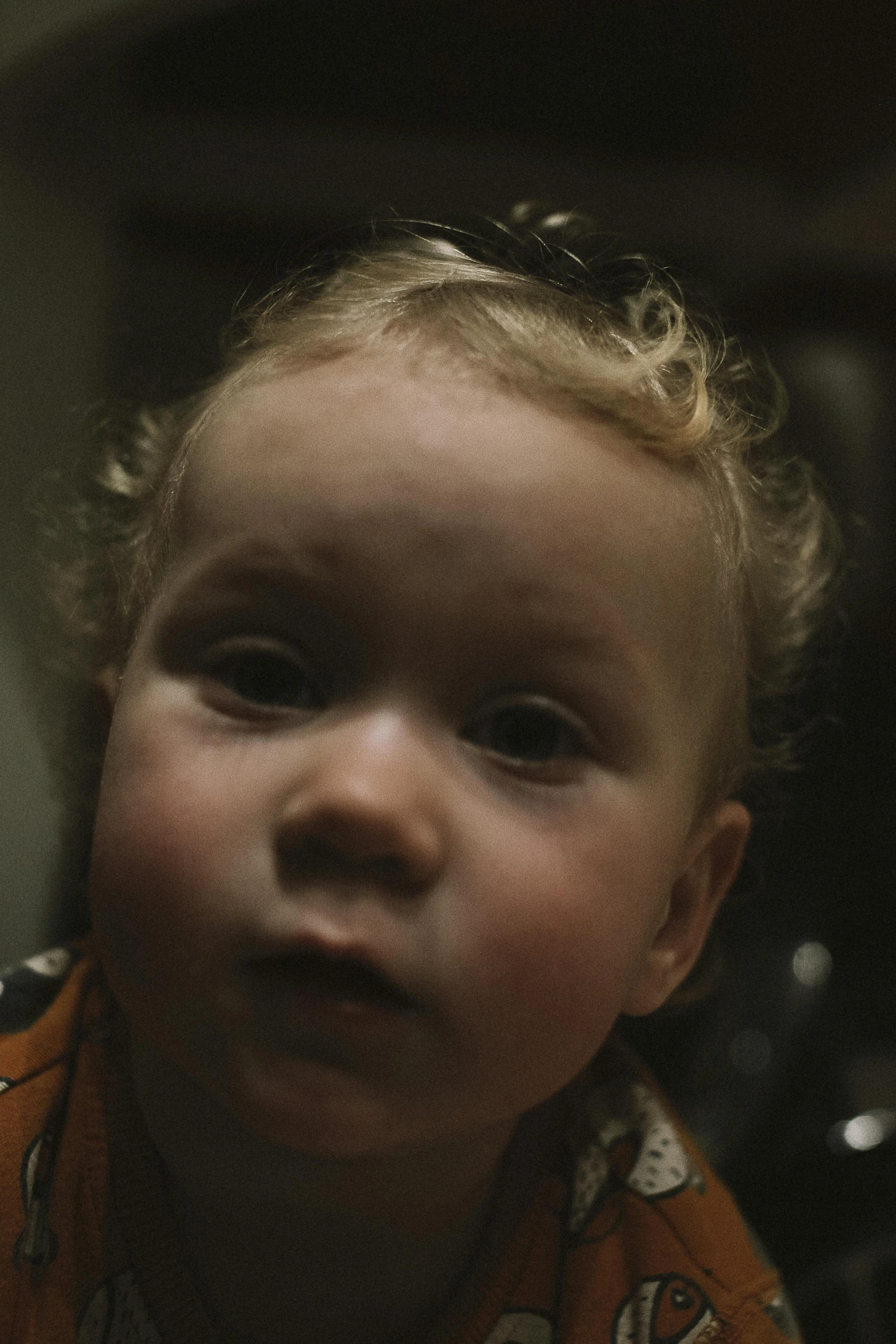 a close up of a child looking at the camera, by David Begbie, trending on reddit, video art, worksafe. cinematic, toddler, curls, 7 0 mm. dramatic lighting