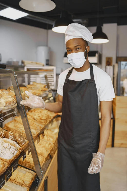 a person wearing a face mask in a bakery, a portrait, pexels, 64x64, rectangle, black man, head to waist
