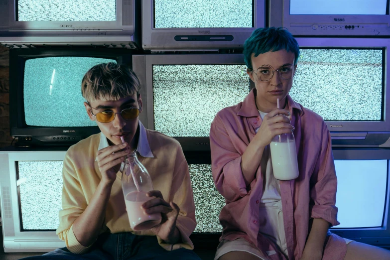 a couple of people sitting next to each other, an album cover, pexels, antipodeans, drink milkshakes together, sophia lillis, pink glasses, lesbians