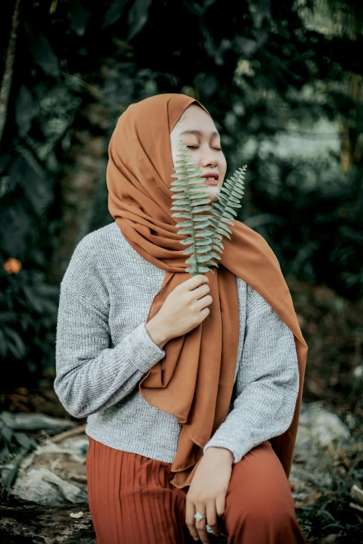 a woman wearing a hijab in a forest, inspired by Mym Tuma, trending on pexels, cinnamon skin color, smart casual, fern, sarong