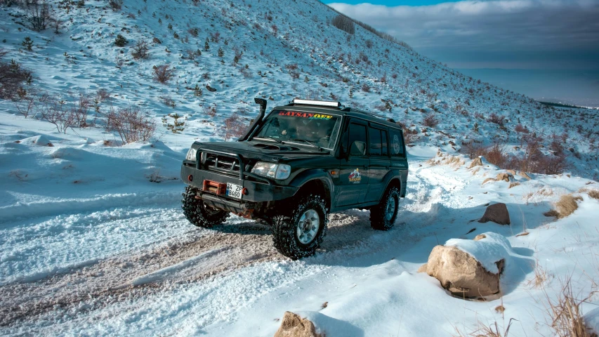 a black suv driving down a snow covered road, a portrait, by Muggur, in the dry rock desert, avatar image