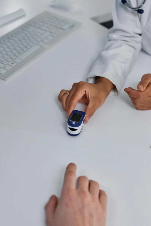 a couple of people that are sitting at a table, holding a syringe, point finger with ring on it, with a lab coat, thumbnail