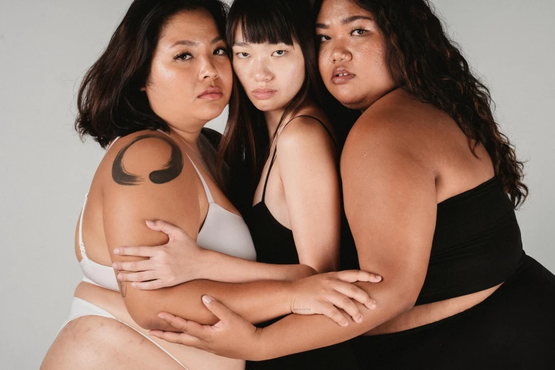 a group of three women standing next to each other, unsplash, realism, thick body, half asian, woman holding another woman, burly
