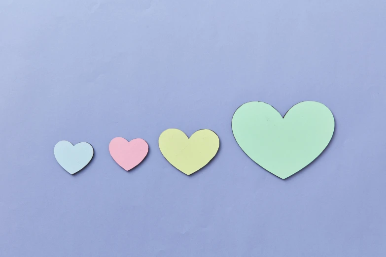 a row of paper hearts on a blue background, trending on pexels, postminimalism, purple green color scheme, happy family, rounded shapes, 1 4 9 3