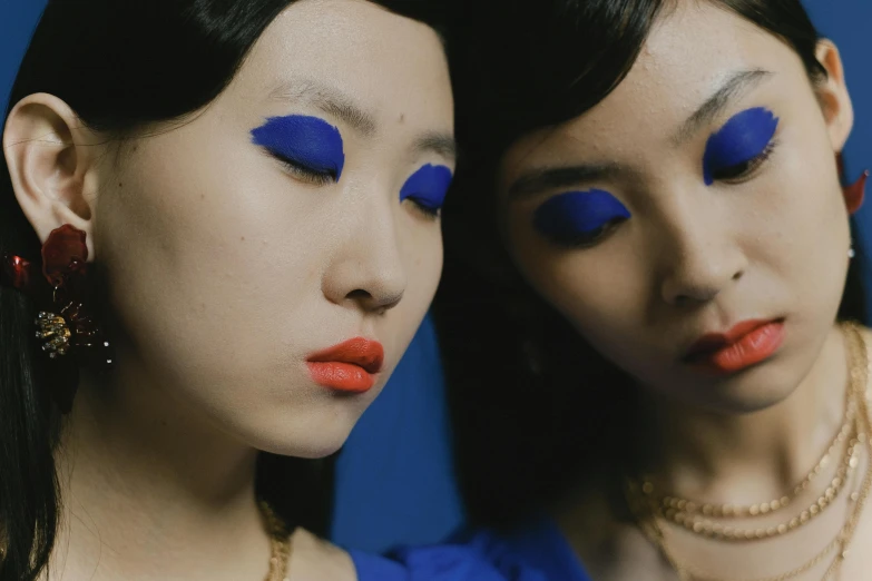 a couple of women standing next to each other, inspired by Yves Klein, trending on pexels, popular south korean makeup, lulu chen, multiple eyes, serge lutens