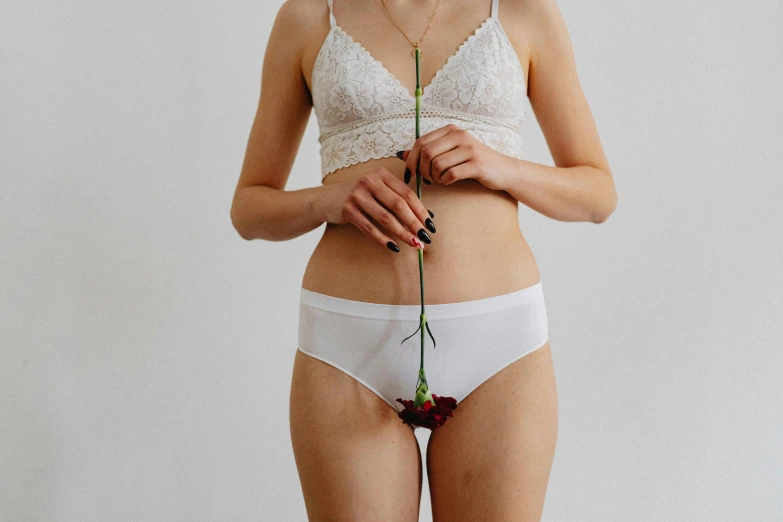 a woman in white underwear holding a flower, trending on pexels, wearing only pants, made of lab tissue, 165 cm tall, unedited