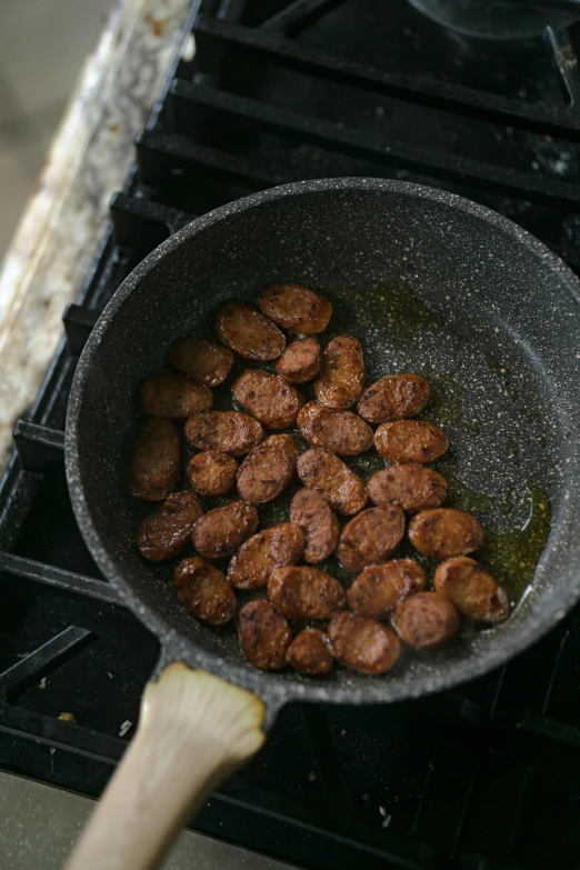 a frying pan filled with meat sitting on top of a stove, inspired by Eugène Boudin, unsplash, kidneys, nugget, 3 / 4 wide shot, ethiopian