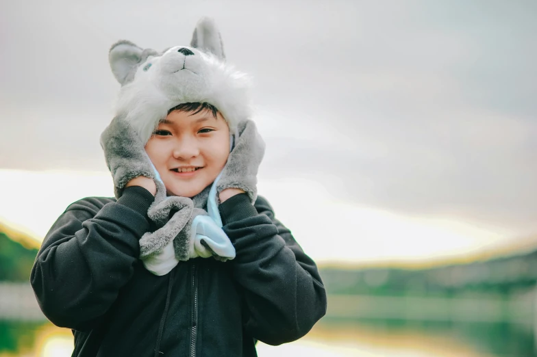 a young boy wearing a furry animal hat, inspired by Caspar Wolf, pexels contest winner, hurufiyya, wearing gloves, joy ang, avatar image, husky