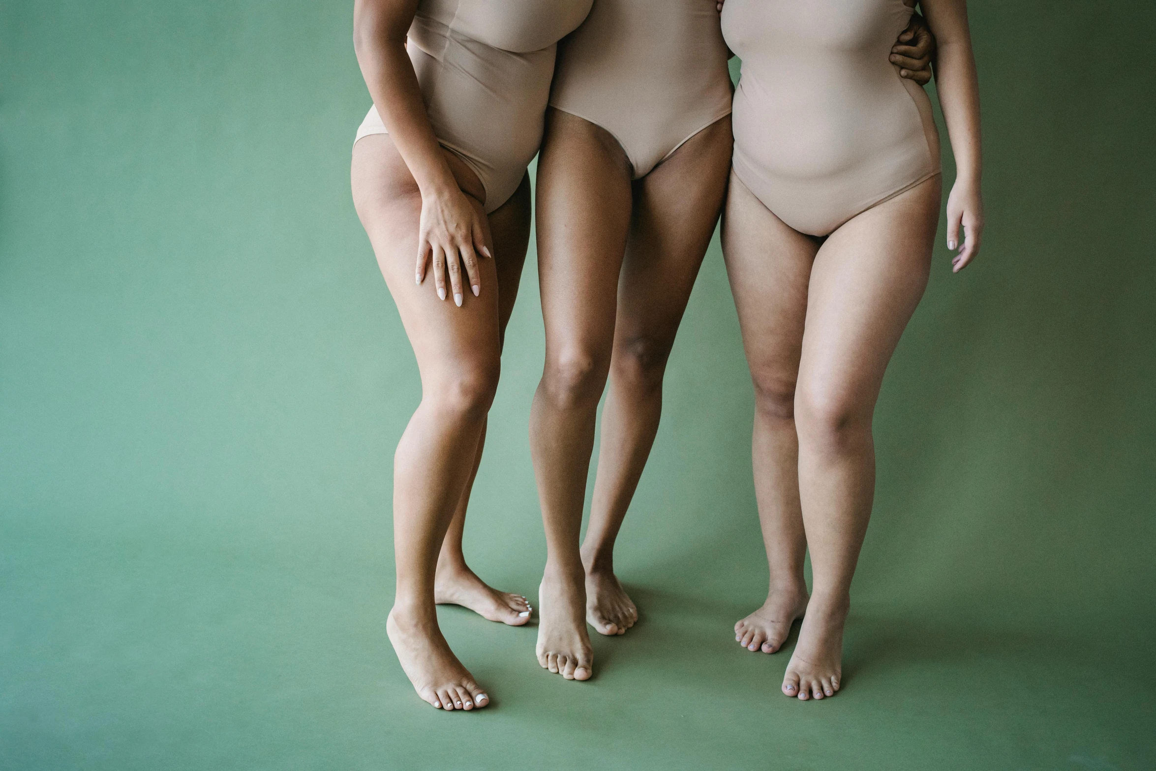 a group of three women standing next to each other, inspired by Vanessa Beecroft, trending on pexels, renaissance, round thighs, muted green, tans, multicoloured