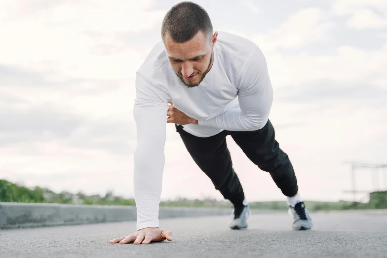 a man in white shirt and black pants doing push ups, pexels contest winner, outside on the ground, background image, maintenance, profile pic