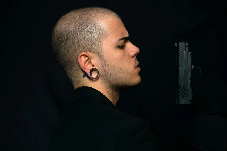 a man with a gun in his hand, an album cover, inspired by Carlo Mense, sleek metal ears, shaved sides, profile picture 1024px, shot on sony alpha dslr-a300