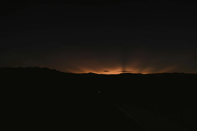 the sun is setting over a mountain range, an album cover, by Andrei Kolkoutine, unsplash, minimalism, night lights, death valley, running lights, black night sky