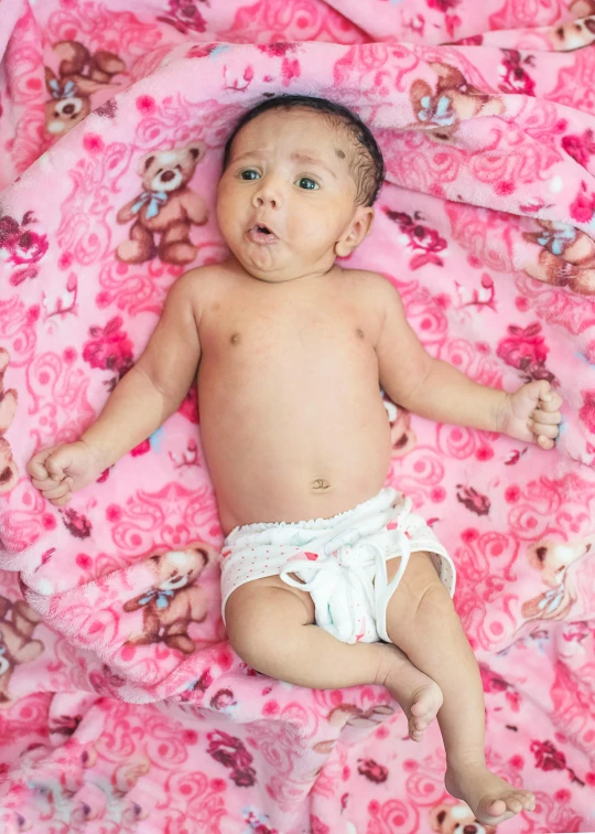 a baby in a diaper laying on a pink blanket, by Julia Pishtar, shutterstock contest winner, laying on roses, large scale photo, promo image, looking serious