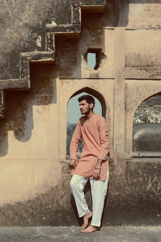 a man sitting on the steps of a building, a colorized photo, inspired by Saurabh Jethani, renaissance, wearing a kurta, in shades of peach, standing near a castle, [ cinematic