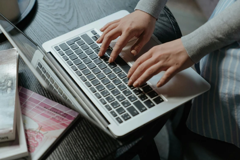 a close up of a person typing on a laptop, pexels, multiple stories, bottom angle, maintenance, looking towards the camera