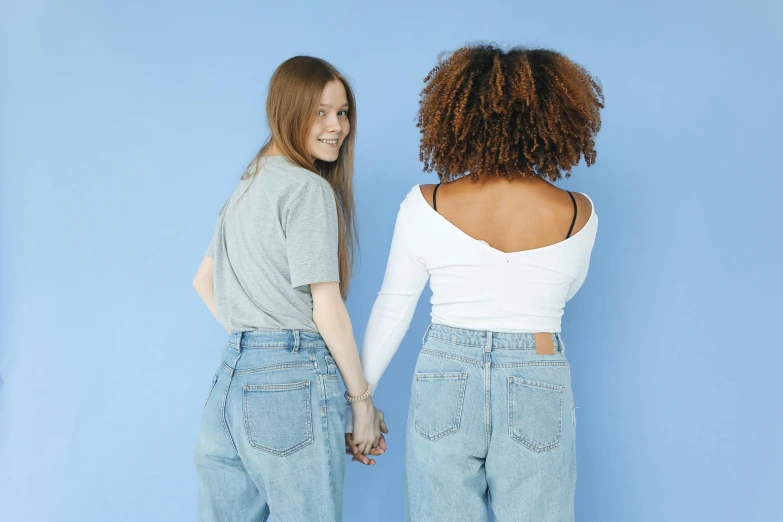 a couple of women standing next to each other, trending on pexels, back arched, white and blue, lengthwise, diverse