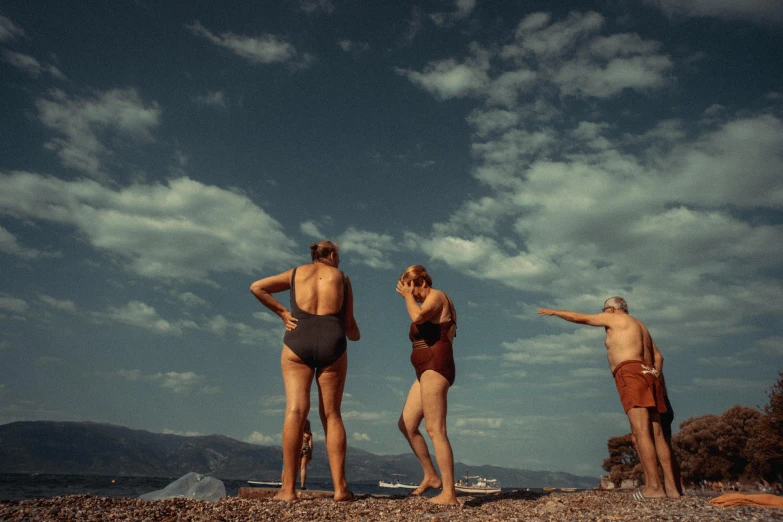 a group of people standing on top of a beach, a colorized photo, pexels contest winner, figuration libre, simin stalenhag, people swimming, greece, cinematic diane arbus