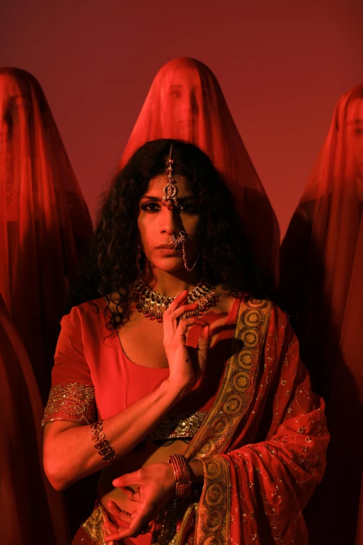 a woman in a red sari poses for a picture, an album cover, transgressive art, elaborate cult robes, trans rights, ( ( theatrical ) ), movie still