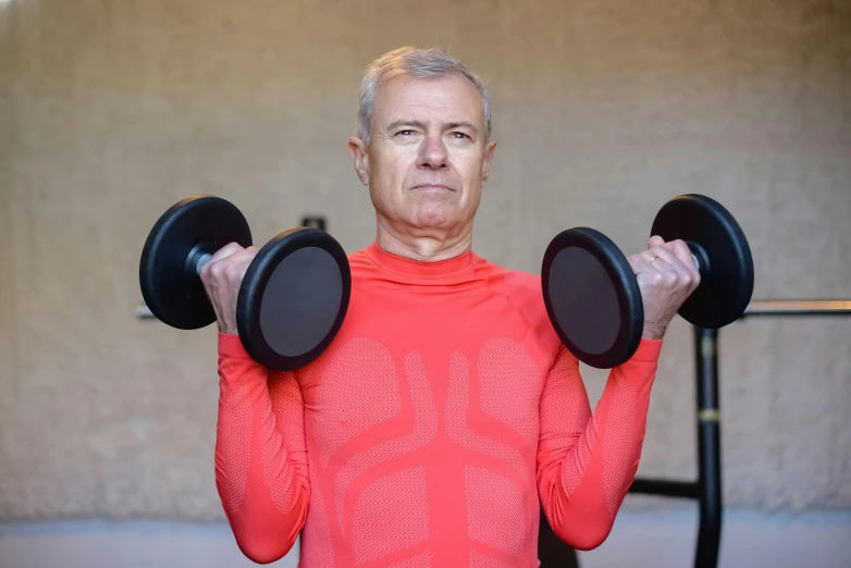 a man in a red shirt holding two black dumbbells, by Jan Rustem, avatar image, older male, skintight suits, lachlan bailey