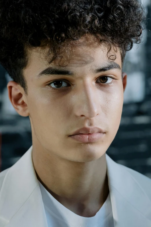 a close up of a person wearing a suit and tie, inspired by Alexis Grimou, renaissance, teen boy, middle eastern skin, curls on top, non binary model