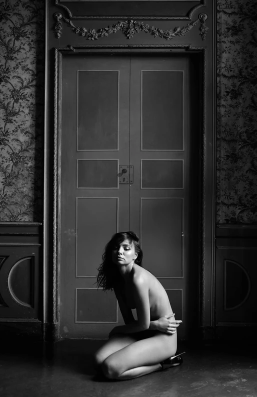 a naked woman sitting on the floor in front of a door, inspired by irakli nadar, frank dillane, ((portrait)), hedi slimane, in a castle