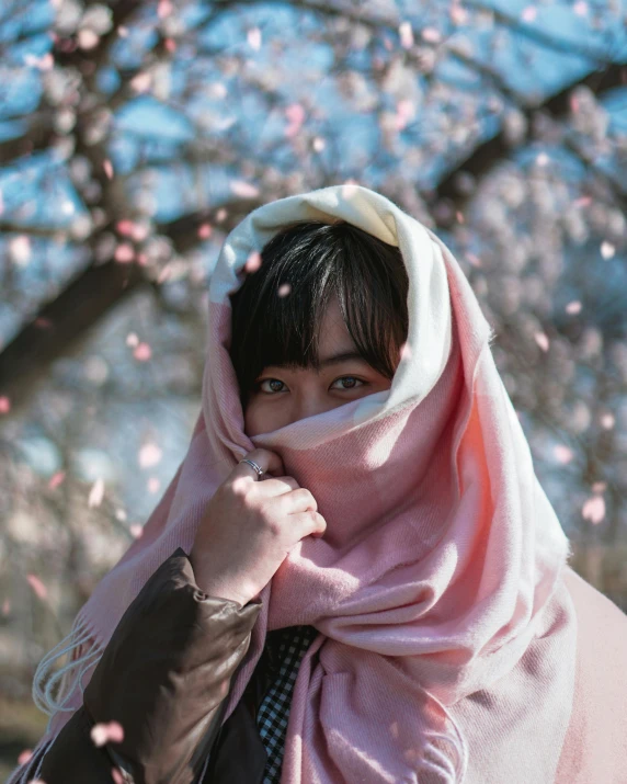 a woman standing under a tree covered in pink flowers, inspired by Itō Shinsui, unsplash contest winner, hijab, covered with blanket, young cute wan asian face, instagram story