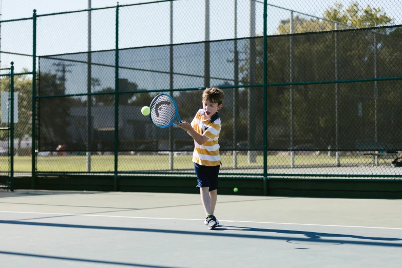 a young boy holding a tennis racquet on a tennis court, by Winona Nelson, pexels contest winner, 1 6 x 1 6, gold, panoramic shot, 15081959 21121991 01012000 4k