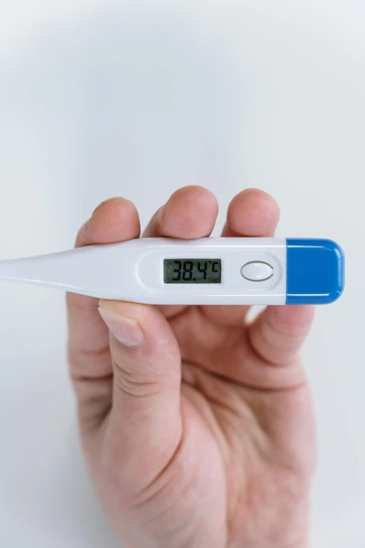 a person holding a digital thermometer in their hand, by Jason Felix, pexels, happening, with a long, blue, contracept, virus