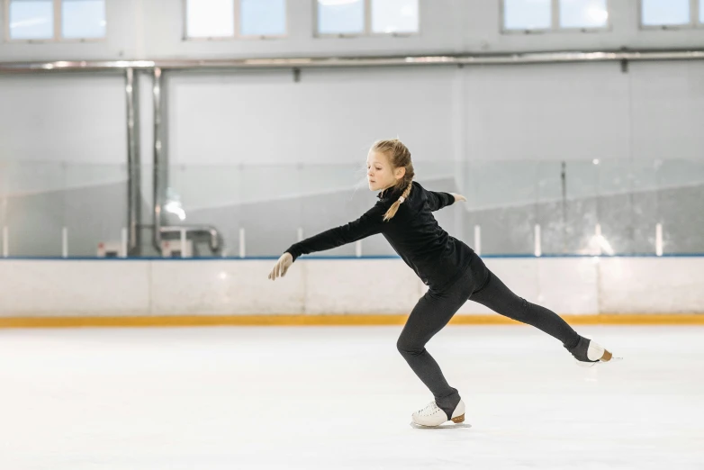 a female figure skating on an ice rink, a portrait, pexels contest winner, arabesque, wearing a tracksuit, thumbnail, 1 6 years old, fan favorite