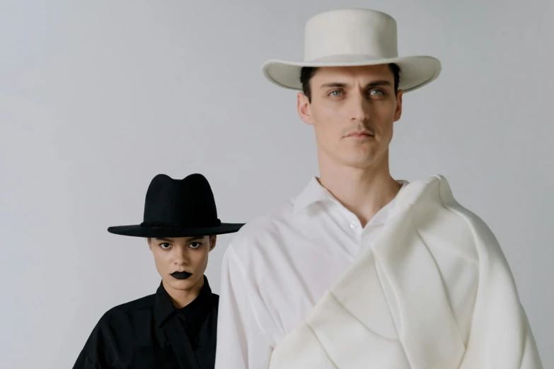 a couple of men standing next to each other, an album cover, unsplash, bauhaus, white hat, haute couture fashion shoot, bella poarch, portrait shot 8 k