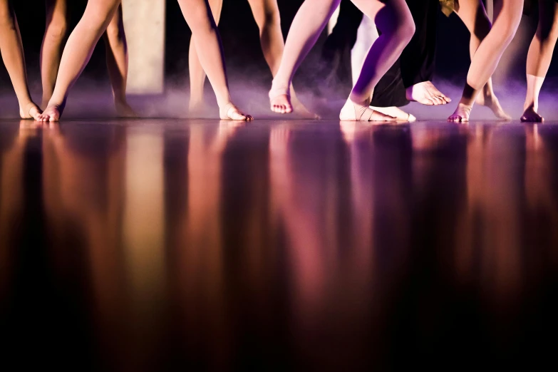 a group of people standing next to each other on a stage, by Lee Loughridge, arabesque, legs taking your pov, liquid light, college, dance scene