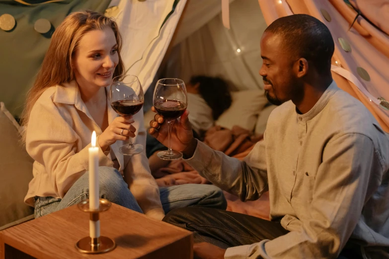 a man and a woman toasting with wine glasses, pexels contest winner, interior of a tent, brown, teenager hangout spot, scene from a movie