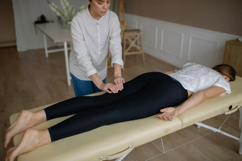 a woman getting a massage in a room, on a table, sanja stikovic, full body transmogrify, high quality photo