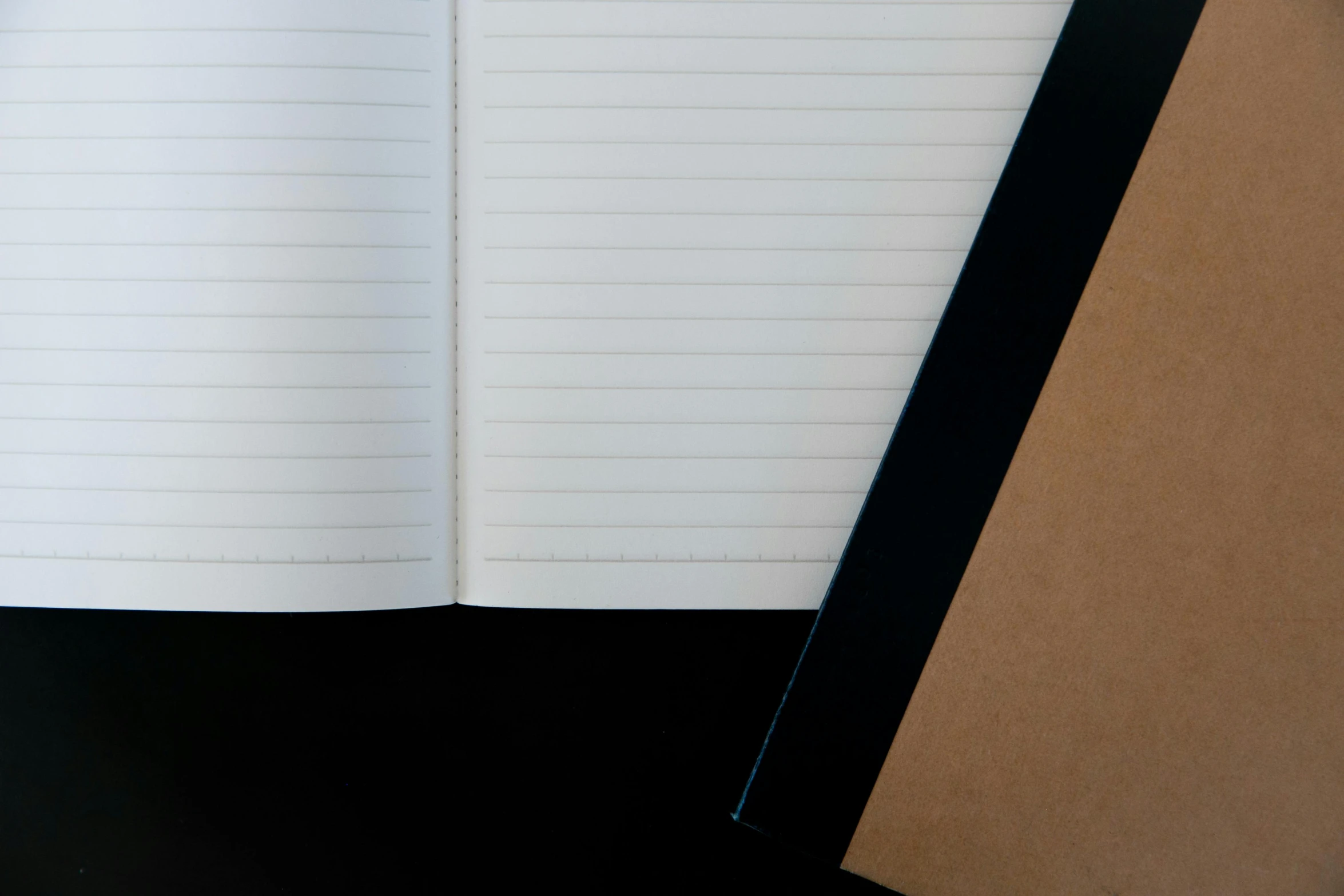 an open notebook sitting on top of a table, by Carey Morris, unsplash, minimalism, standing with a black background, brown paper, whiteboards, very elongated lines