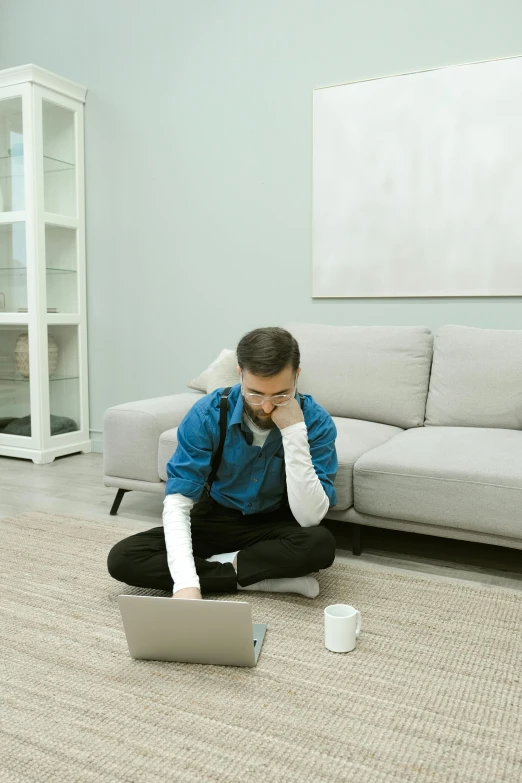 a man sitting on the floor using a laptop, bored ape nft, instagram post, distraught, sitting with wrists together