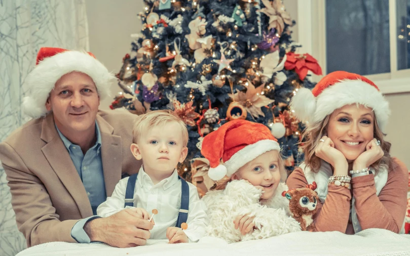 a family posing for a picture in front of a christmas tree, a colorized photo, by Adam Marczyński, pexels, incoherents, caring fatherly wide forehead, close up portrait photo, 15081959 21121991 01012000 4k, thumbnail