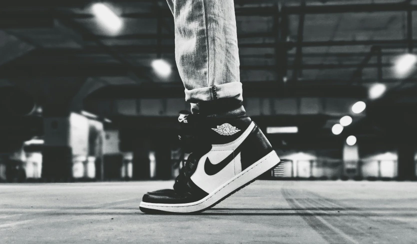 a black and white photo of a pair of sneakers, a black and white photo, trending on unsplash, air jordan 1 high, model posing, two - tone, 🔥 😎 🕹️ 👀