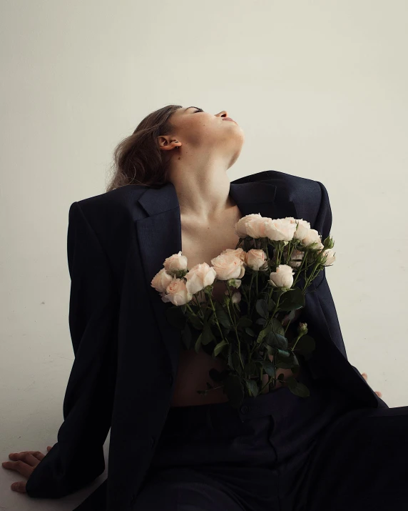 a woman in a suit holding a bunch of flowers, inspired by Elsa Bleda, making out, non binary model, instagram post, flowers growing out of his body