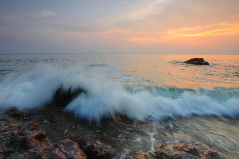 a large body of water sitting on top of a rocky beach, pexels contest winner, romanticism, waves crashing, end of day, thawan duchanee, mutiversal tsunami