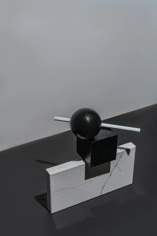 a black object sitting on top of a white box, an abstract sculpture, unsplash, suprematism, flying black marble balls, ignant, donglu yu, portrait of small