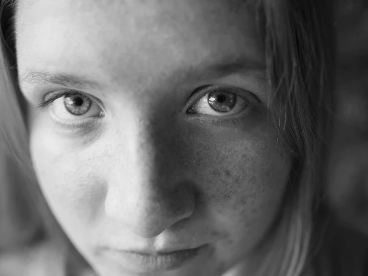a black and white photo of a woman with freckles, pixabay, portrait of normal teenage girl, clear eyes looking into camera, young blonde woman, concerned