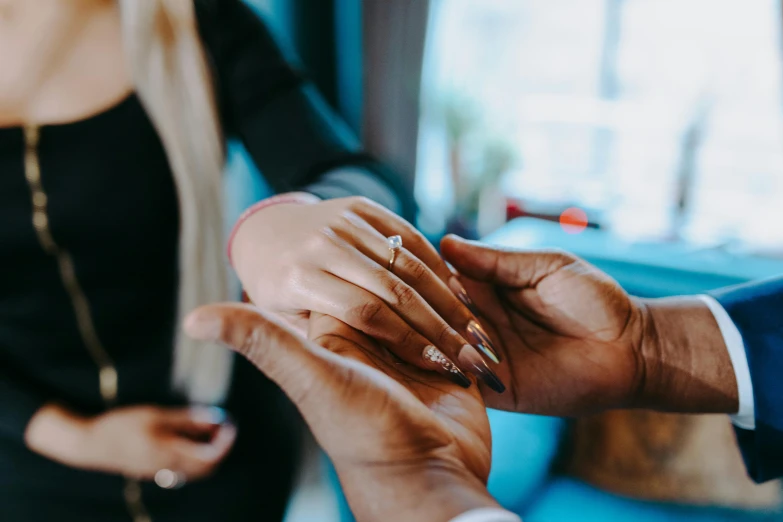 a man putting a wedding ring on a woman's finger, by Julia Pishtar, pexels contest winner, colourised, thumbnail, teaser, man proposing his girlfriend