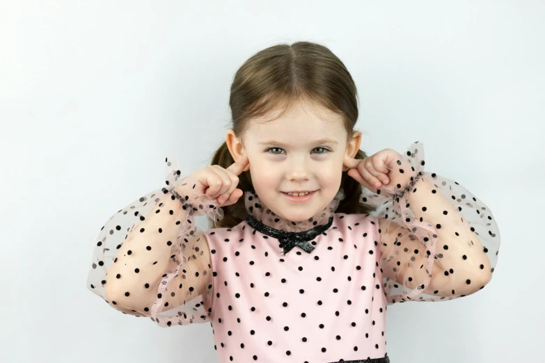 a little girl wearing a pink polka dot dress, an album cover, pexels, shrugging, black ears, close up portrait photo, intelligence