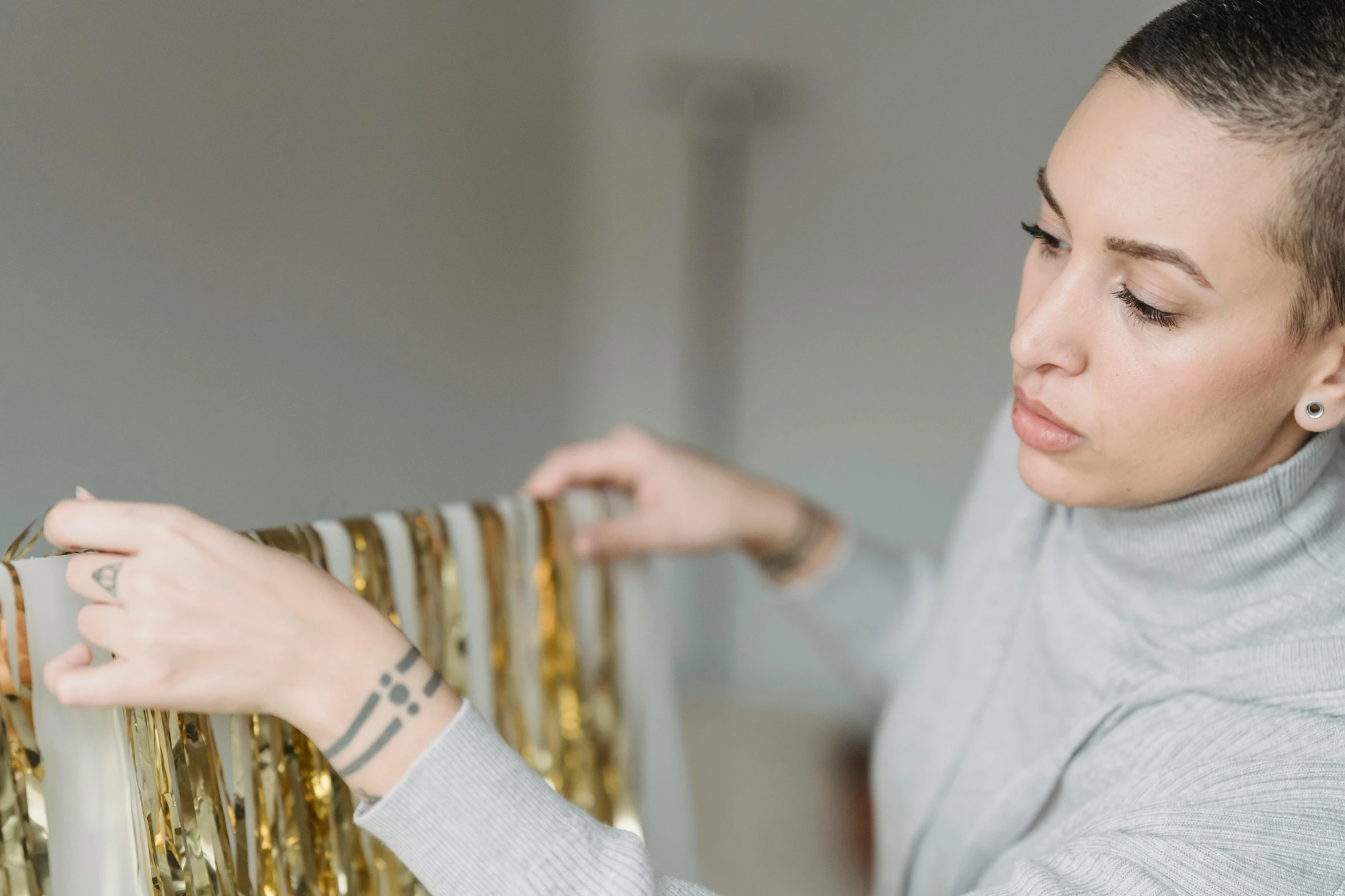 a woman standing next to a radiator in a room, an album cover, trending on pexels, arts and crafts movement, golden ribbons, glitter, profile image, golden thread