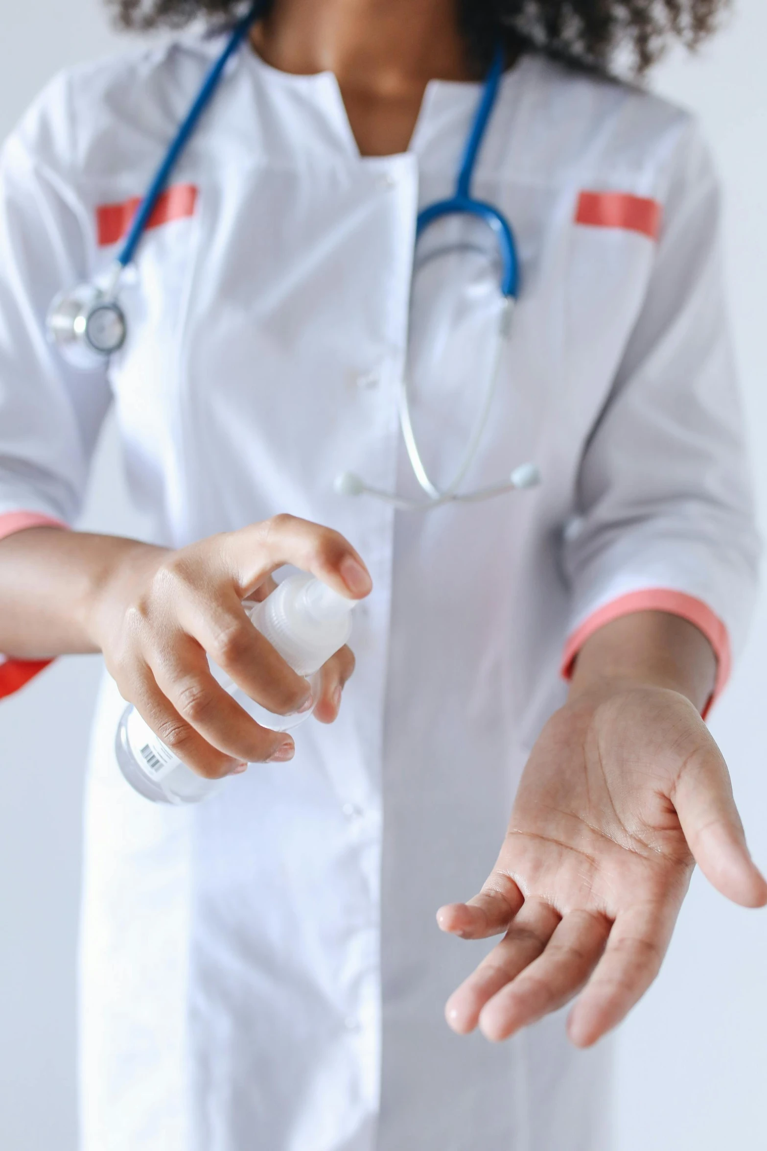 a woman in a white lab coat holding a bottle of hand sanitizer, a picture, shutterstock, square, stethoscope, contain, do